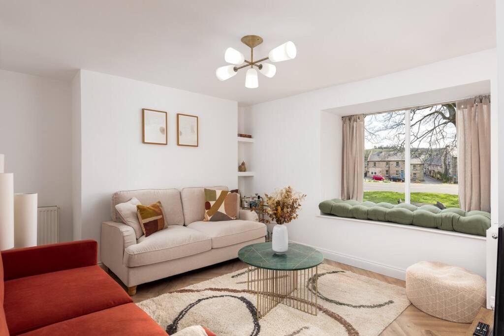 a living room with a couch and a window at Luxe Design - Chic Cottage - Heart of Rothbury in Rothbury