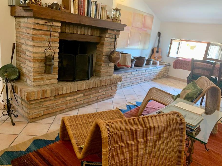 sala de estar con chimenea de ladrillo y sofá en Gubbio-Gualdo Tadino Incantevole mansarda con terrazza, en Gualdo Tadino