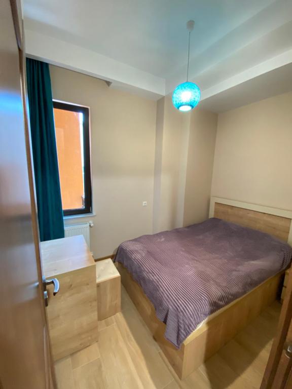 um pequeno quarto com uma cama e uma janela em Lovely and cozy apartment! em Kutaisi