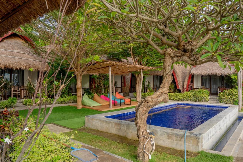 a resort with a swimming pool and a tree at Krisna Bungalows and Restaurant in Sekotong