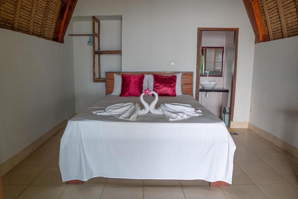 a bed with two swans made out of towels at Krisna Bungalows and Restaurant in Sekotong