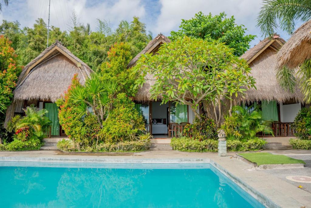 a villa with a swimming pool and a resort at Krisna Bungalows and Restaurant in Sekotong
