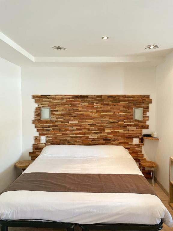 a bedroom with a bed with a brick wall at Hôtel Beau Soleil in Le Lavandou