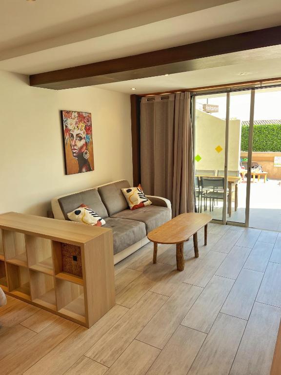 a living room with a couch and a table at Hôtel Beau Soleil in Le Lavandou