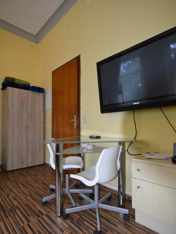 Zimmer mit einem Tisch und 2 Stühlen sowie einem Flachbild-TV in der Unterkunft MA-6 2Gs in Krefeld