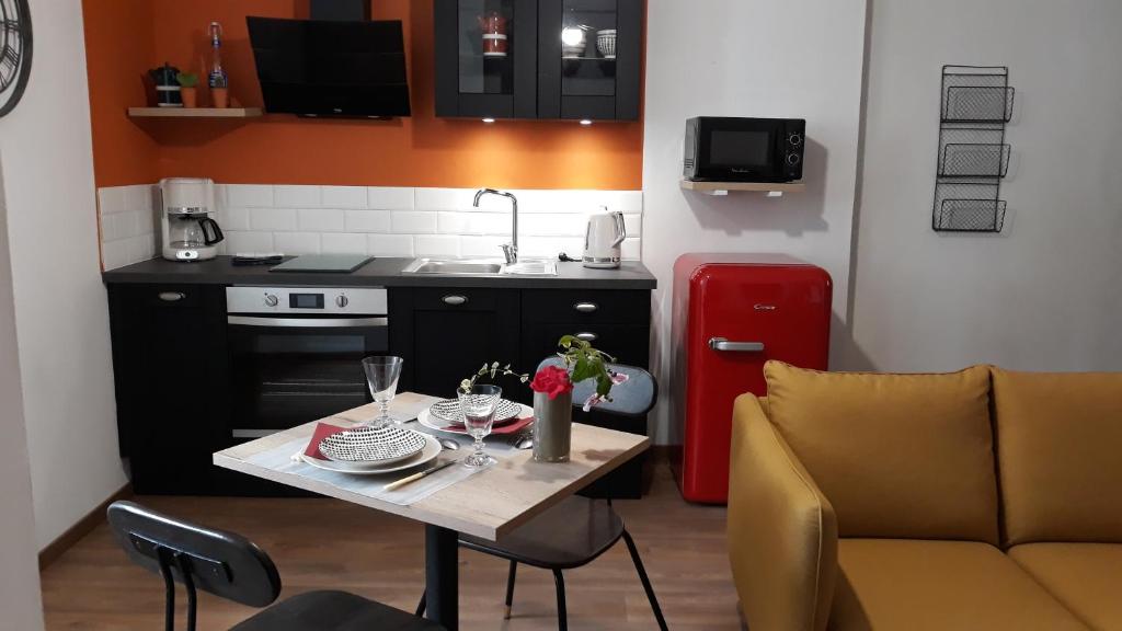 Il comprend une petite cuisine avec une table et un réfrigérateur rouge. dans l'établissement iSABELLE, à Vannes