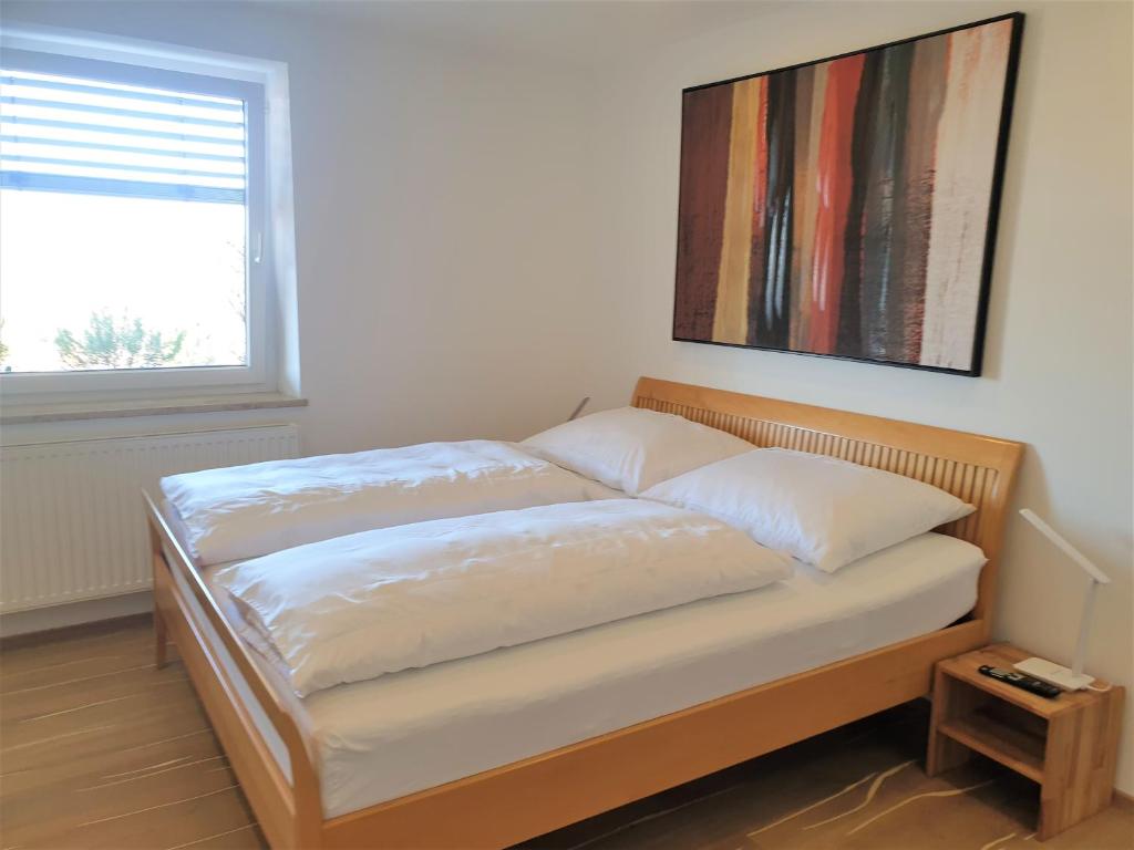 a bed in a room with a picture on the wall at Haus am Weinberg in Seekirchen am Wallersee