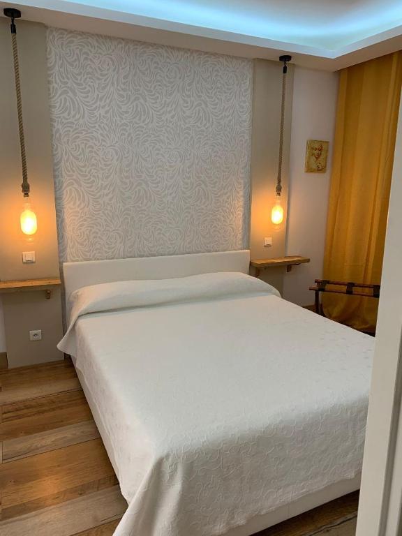 a bedroom with a large white bed with two lights at Sole e Mare in Galeria