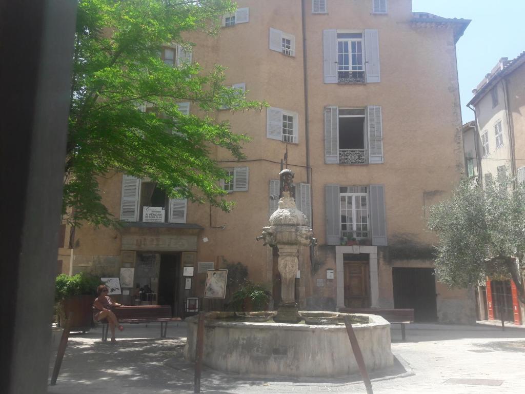 a building with a fountain in front of a building at Apartment in the heart of Cotignac in Cotignac