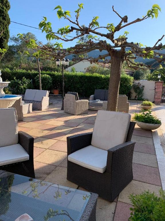 a group of chairs sitting on a patio with a tree at Sole e Mare in Galeria