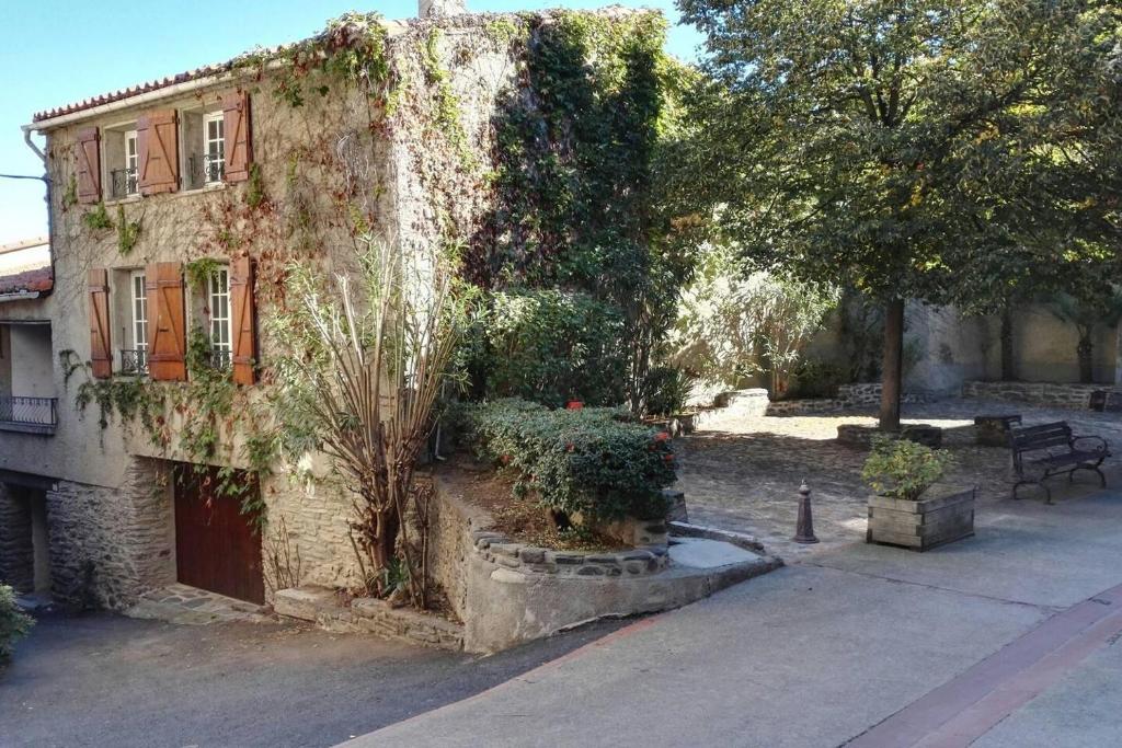 een oud stenen gebouw met planten aan de zijkant bij Catalan Cottage terrace and secure garage in Rigarda