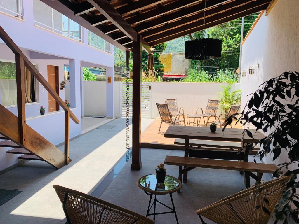 a patio with a bench and chairs and a table at Lila Limao Hostel in Abraão