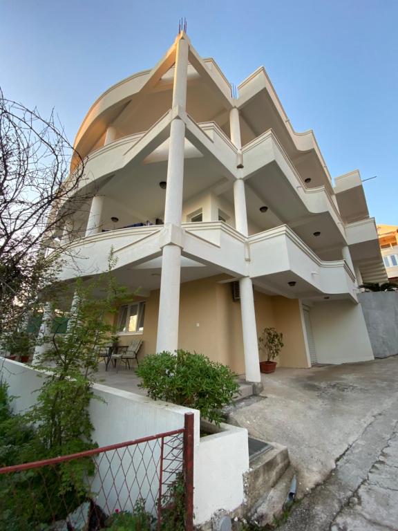 a large white building with a fence in front of it at Dajkovic Apartmani in Bar