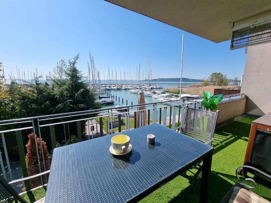 a blue table on a balcony with a view of a marina at Bilberry Apartman in Balatonfüred