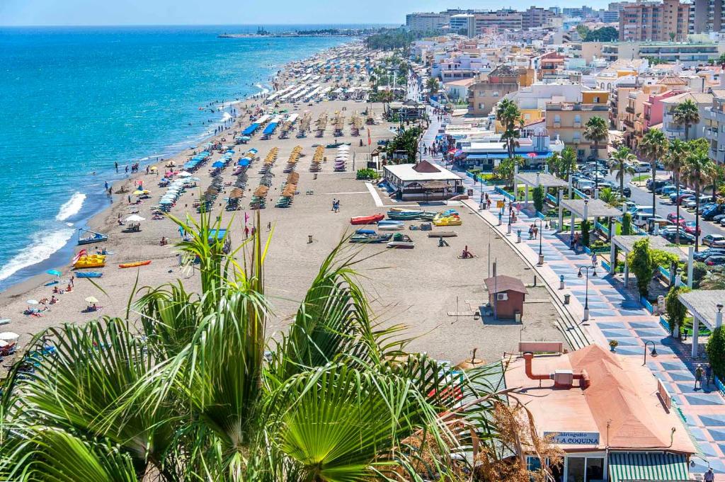z powietrza widok na plażę z ludźmi i ocean w obiekcie Semi-detached Adosado con Encanto -130 m2 - WiFi 600 Mb - Piscina Comunitaria - Patio Privado w mieście Torremolinos
