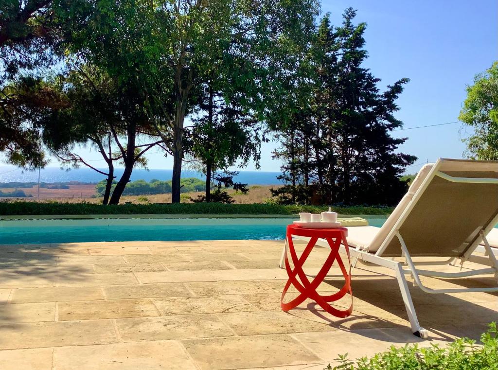 a chair and a table next to a pool at Kubo Sea Views Luxury Escape in Lecce
