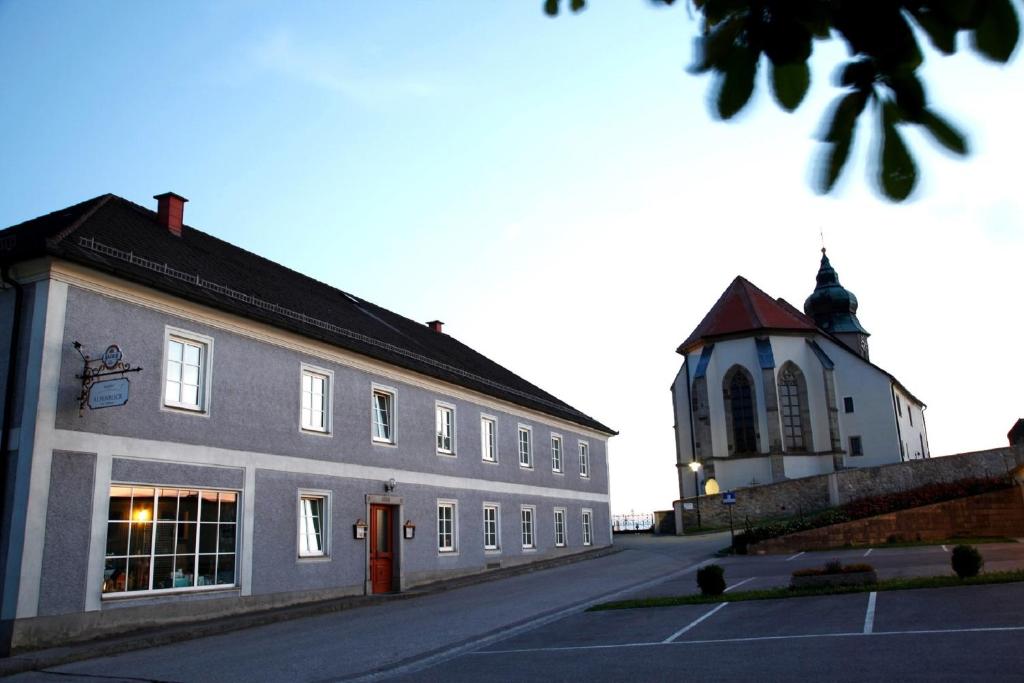 un bâtiment avec une tour d'horloge à côté d'une rue dans l'établissement Gasthof Alpenblick, à Amstetten