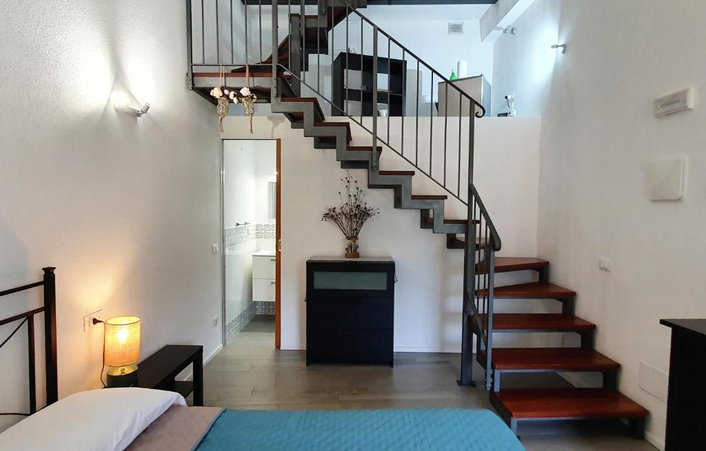 a spiral staircase in a bedroom with a bed at Arbanella in Corniglia