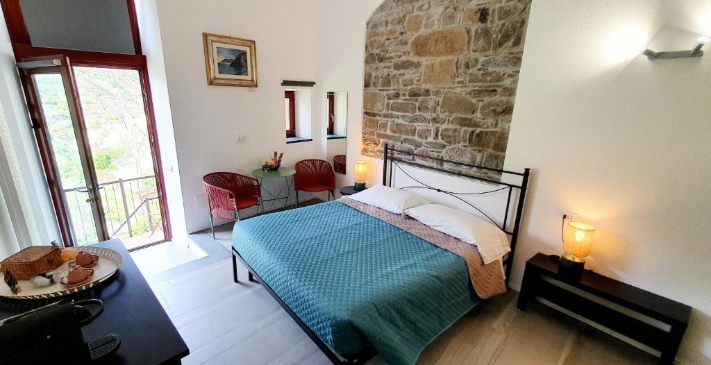 a bedroom with a bed and a stone wall at Arbanella in Corniglia