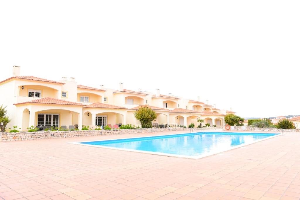 una piscina frente a un gran edificio en Casa América, en Casal da Lagoa Seca