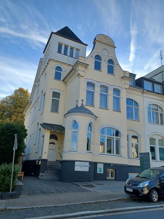 un bâtiment avec une voiture garée devant lui dans l'établissement Bredeney View, à Essen