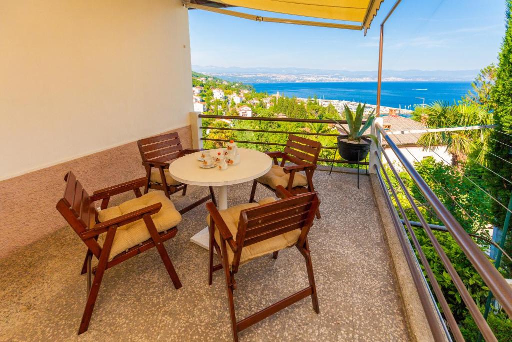 Un balcón con mesa y sillas y el mar. en Apartment Hana, en Ičići