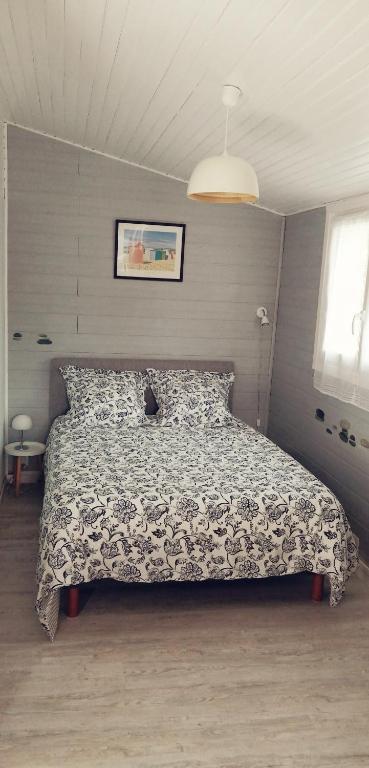 une chambre avec un lit sur lequel est assis un chat dans l'établissement Chambre d'hôtes sur les plages du débarquement, à Ver-sur-Mer