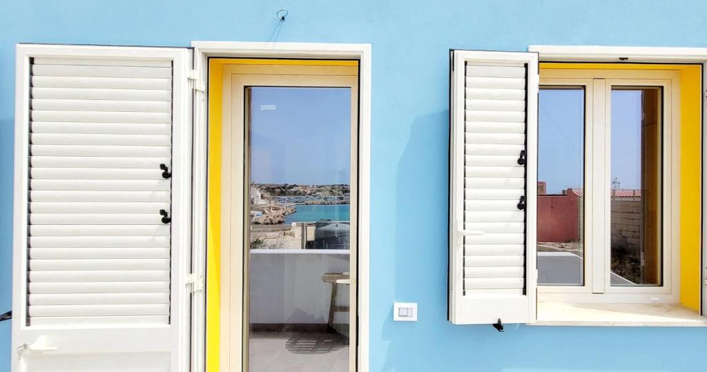 two windows on a blue wall with a view at Il maestro di nodi - Casa vista mare in Lampedusa