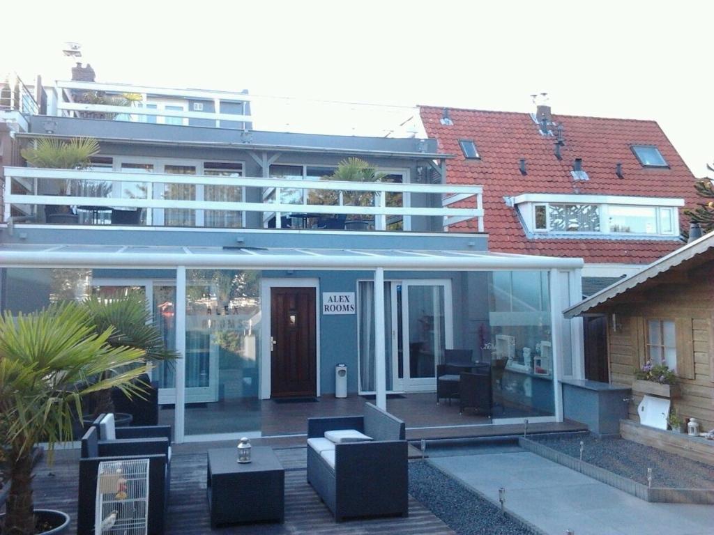 een groot gebouw met glazen deuren en een patio bij Alex Rooms in Zwanenburg