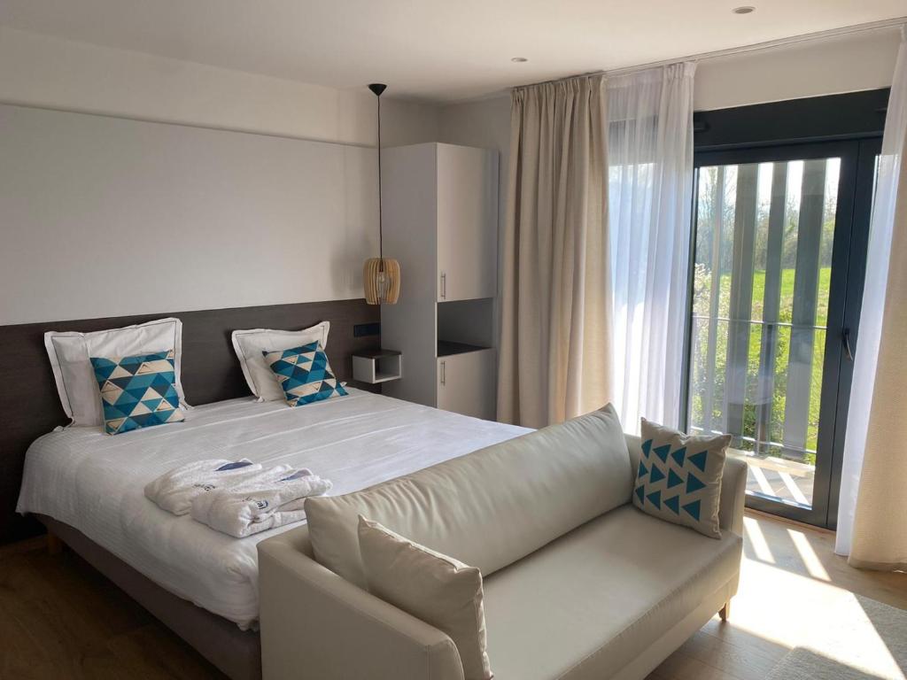 a bedroom with a white bed and a couch at Villa Thermae Santenay in Santenay