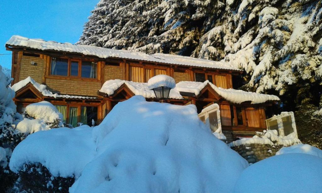 a house covered in snow in front of a mountain at LUZ DE LUNA 2 in San Carlos de Bariloche