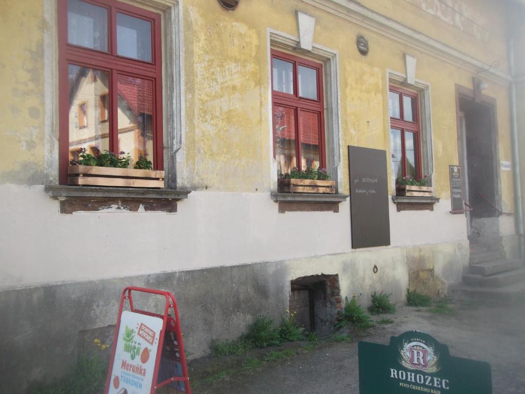a building with windows and a sign in front of it at Restaurace s ubytováním in Křižany