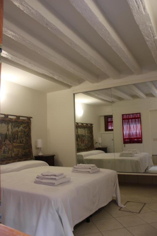 sypialnia z dwoma łóżkami i dużym lustrem w obiekcie CHIARA HOUSE VENICE w Wenecji