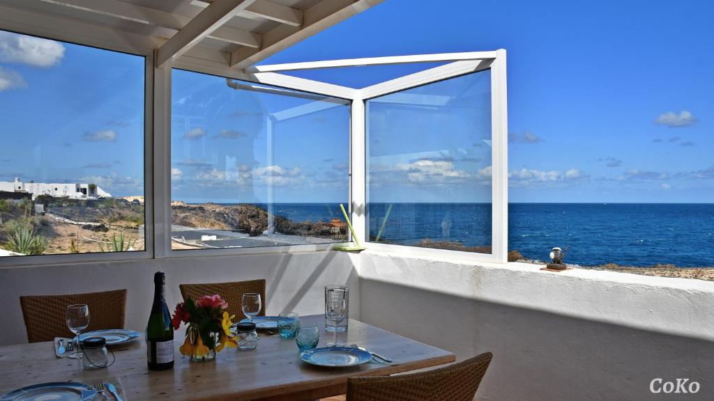 a dining table with a view of the ocean at PERLE DES MEERES in Charco del Palo