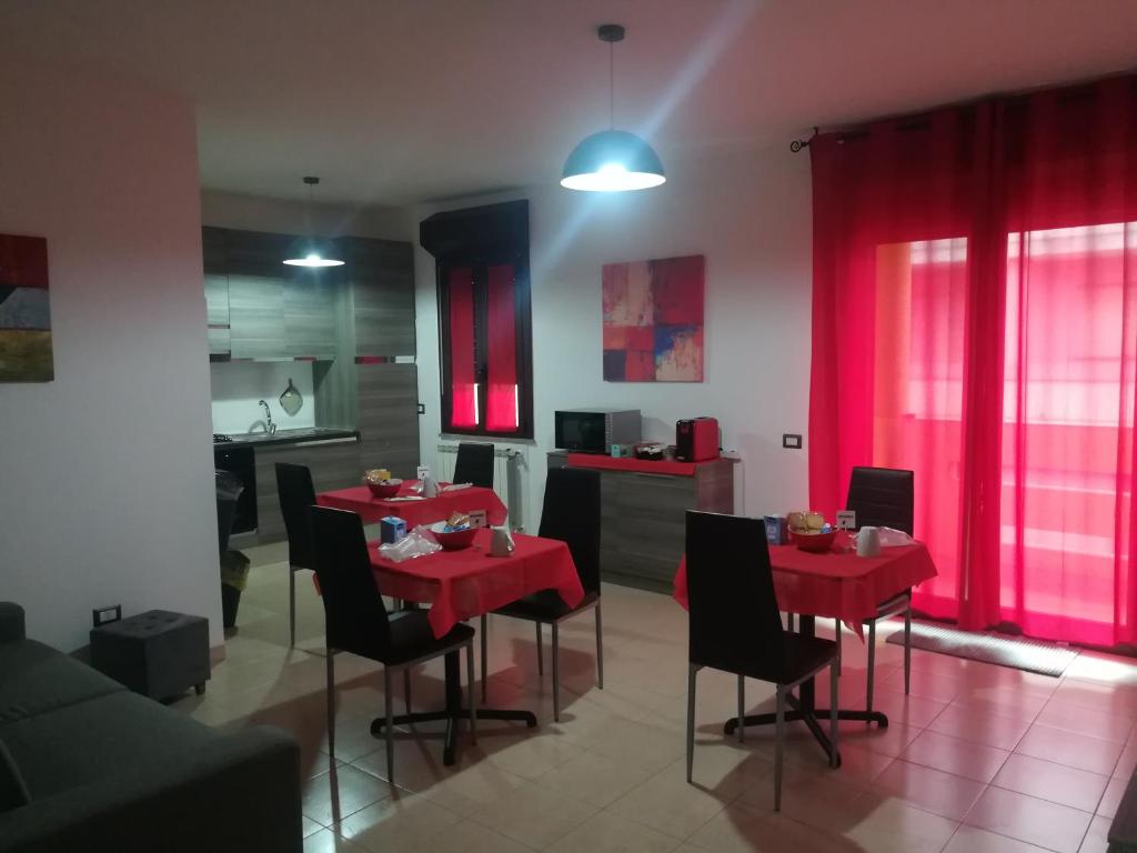 sala de estar con mesa roja y sillas en Guesthouse Loru, en Sestu