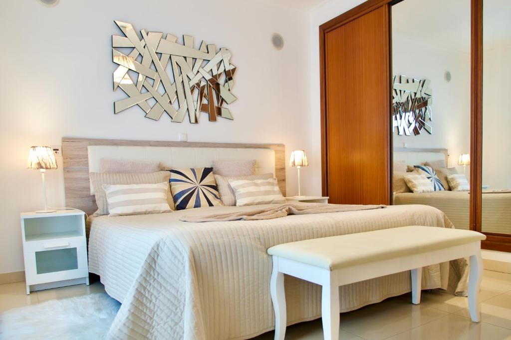 sypialnia z łóżkiem ze stołem i lustrem w obiekcie Edifício Tomás w mieście Ferragudo
