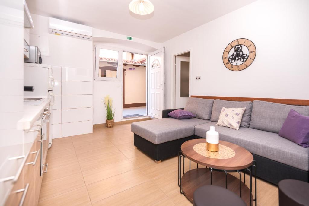 uma sala de estar com um sofá e uma mesa em Anamari apartment em Split