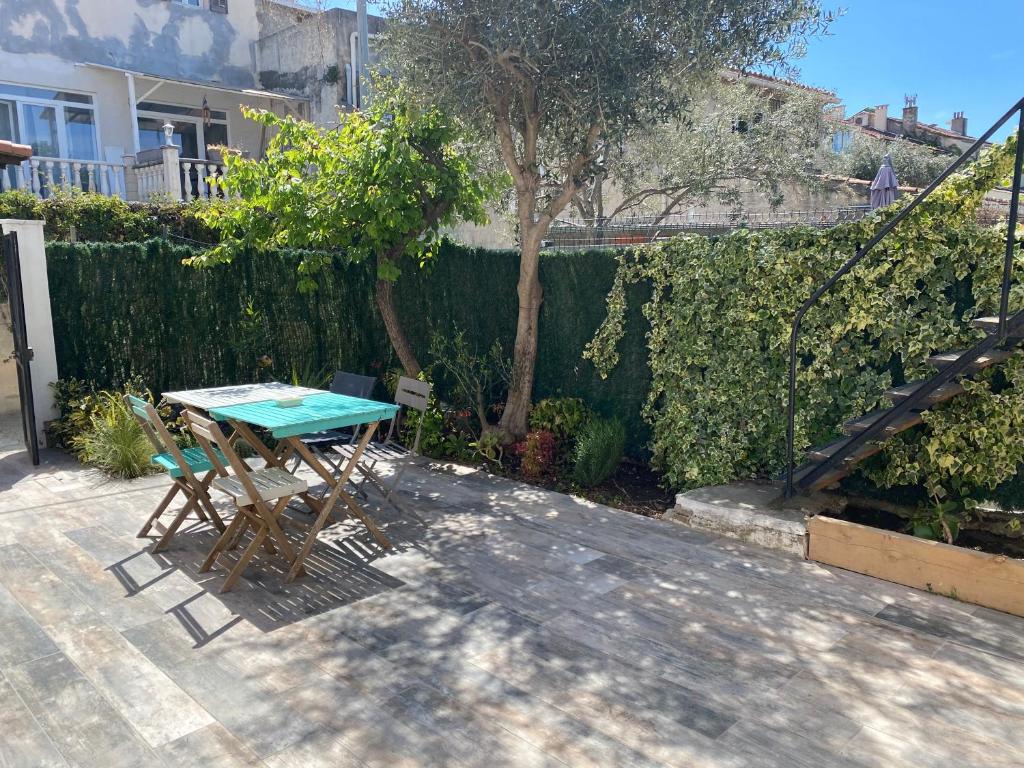 a table and chairs in a backyard with a fence at Maison au calme proche du stade in Marseille