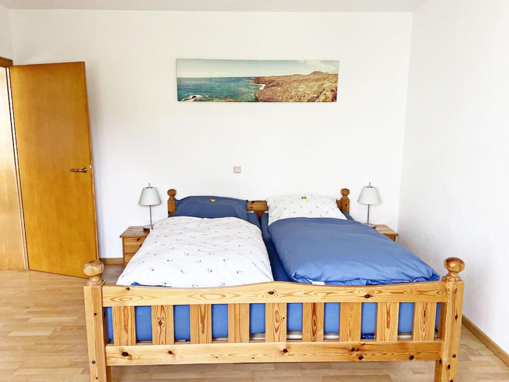 een slaapkamer met een houten bed en een schilderij aan de muur bij FEWO Mein Panama in Bernkastel-Kues