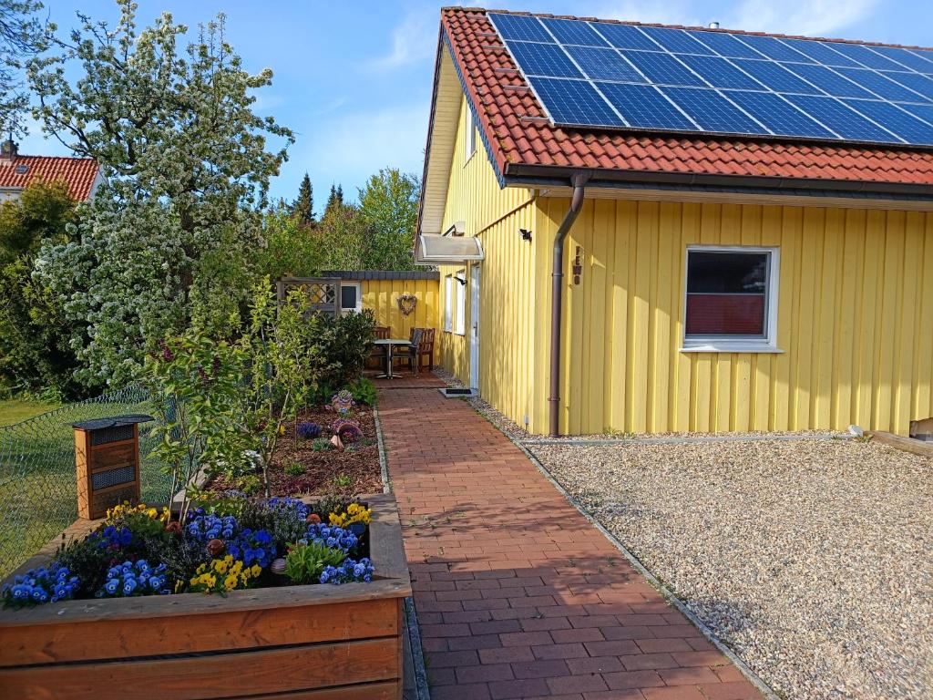 a yellow house with solar panels on the roof at FEWO Borchert in Cuxhaven
