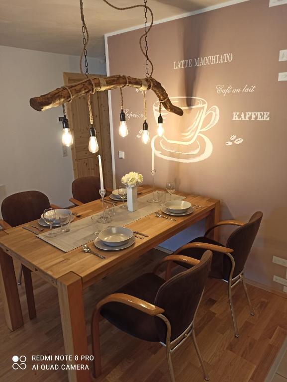 einen Esstisch mit Stühlen und einem Kronleuchter in der Unterkunft Neue Ferienwohnung in Illmensee Ruschweiler in Illmensee