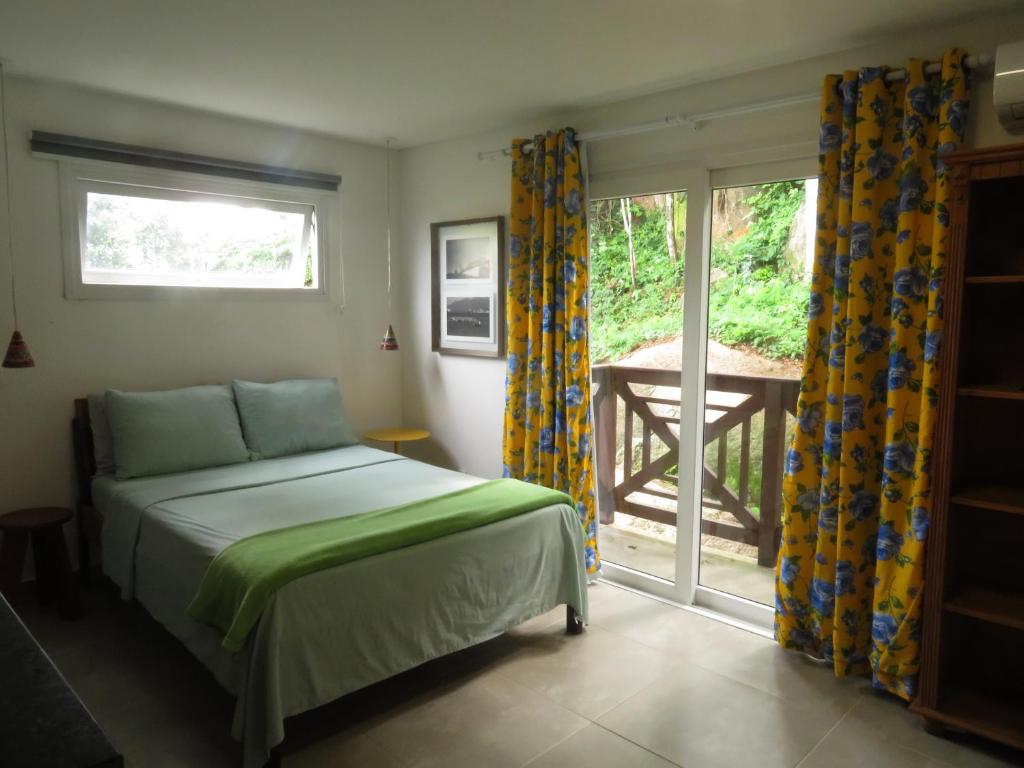 um quarto com uma cama e uma porta de vidro deslizante em Pátio Floriparadise em Florianópolis