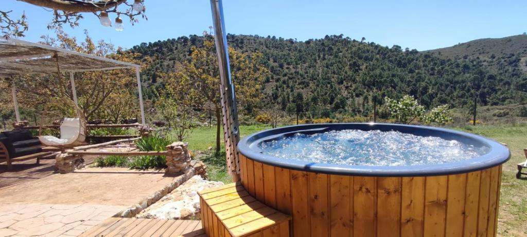 een grote hot tub op een houten terras bij Esencia Lodge - luxurious off-grid cabin retreat in Almuñécar