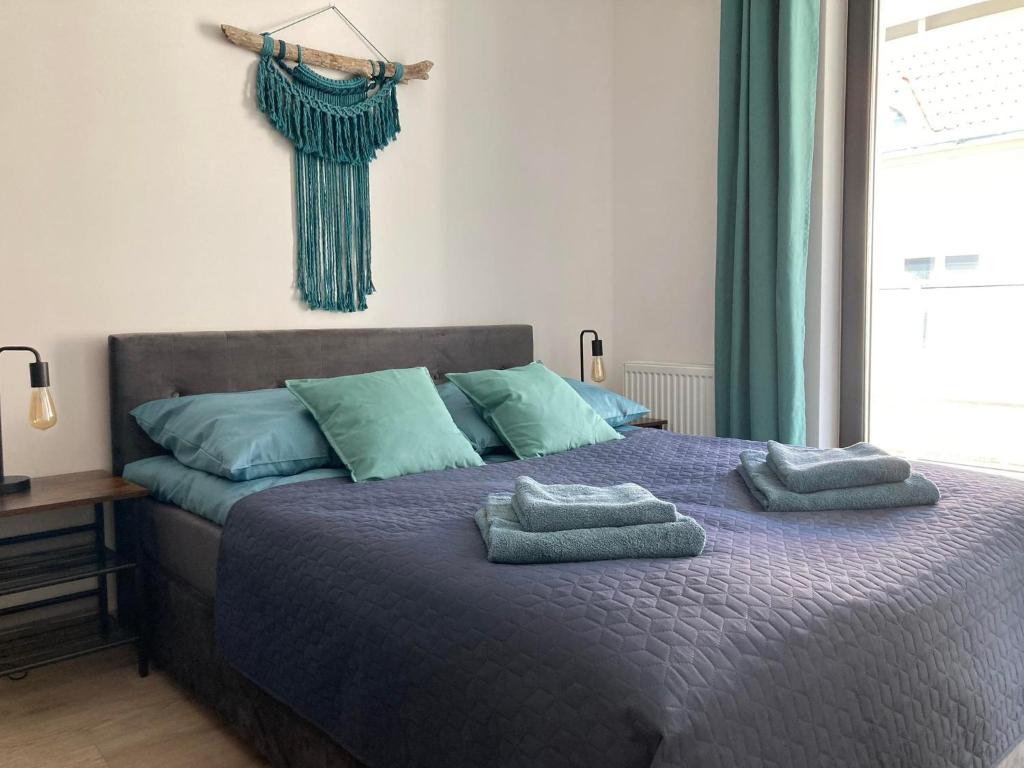 a bedroom with a bed with two towels on it at Apartament Wrzeszcz, Kamienice Kołłątaja in Gdańsk