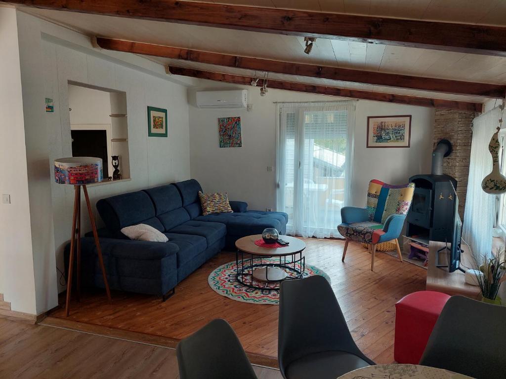 a living room with a blue couch and chairs at Apartment Cvita in Zadar