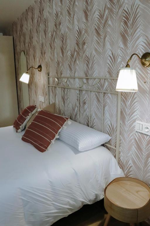 a bedroom with a white bed with two lamps at Pura Agro Vida in Galizano