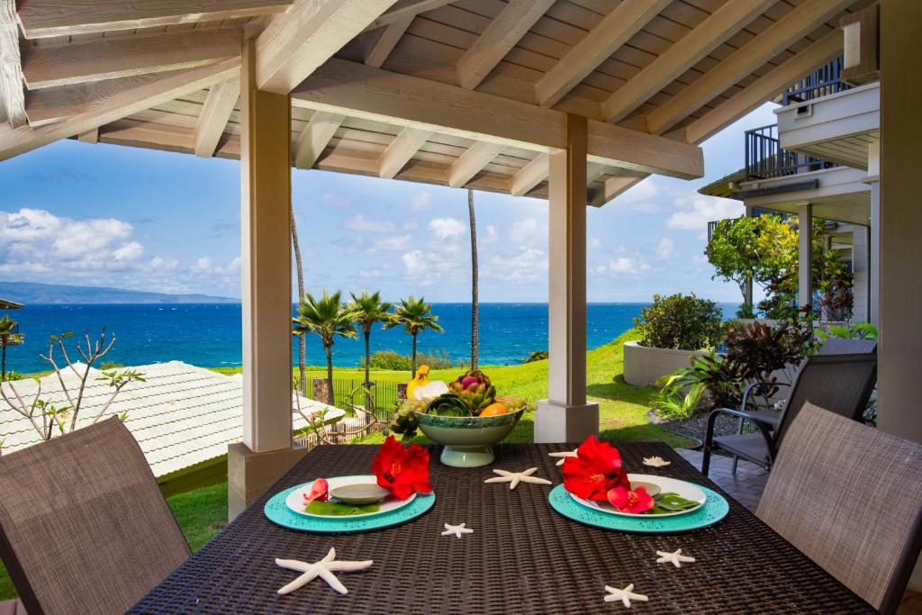 a table with two plates of food on a patio at Kapalua Bay Vill 23G1 Ocean front 1 BD 1BA villa in Kahana