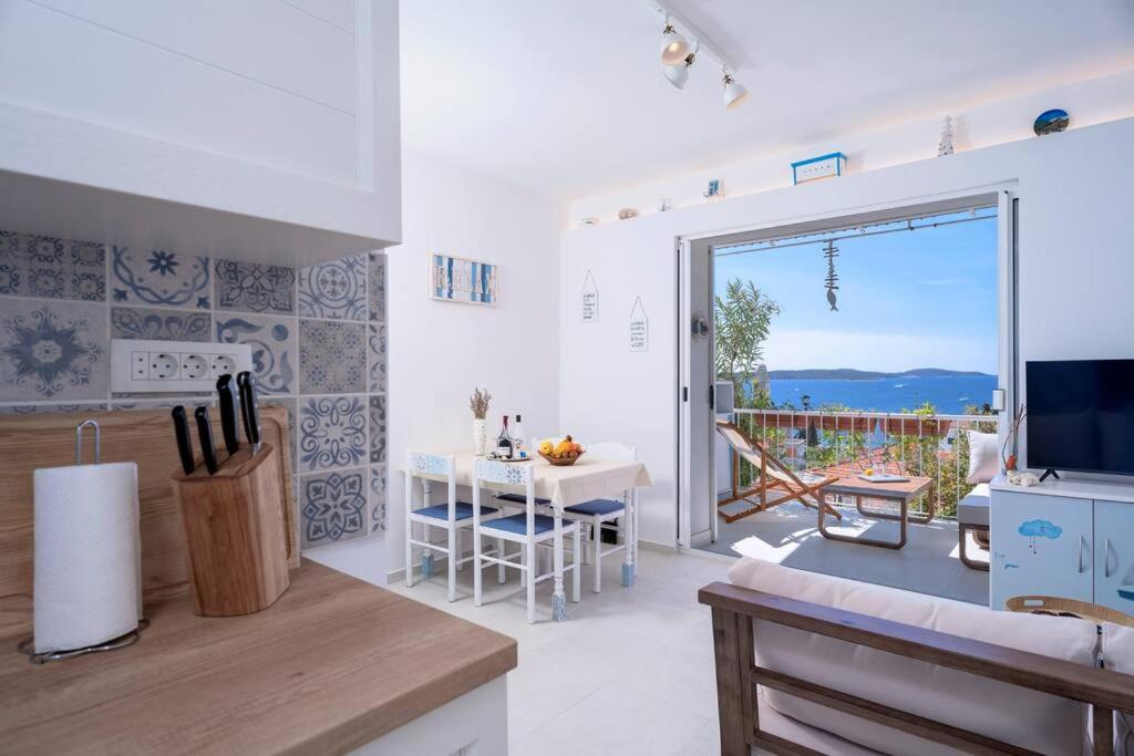 a kitchen and living room with a view of the ocean at AWAKEN Gorgeous Sea View Apartment in Hvar