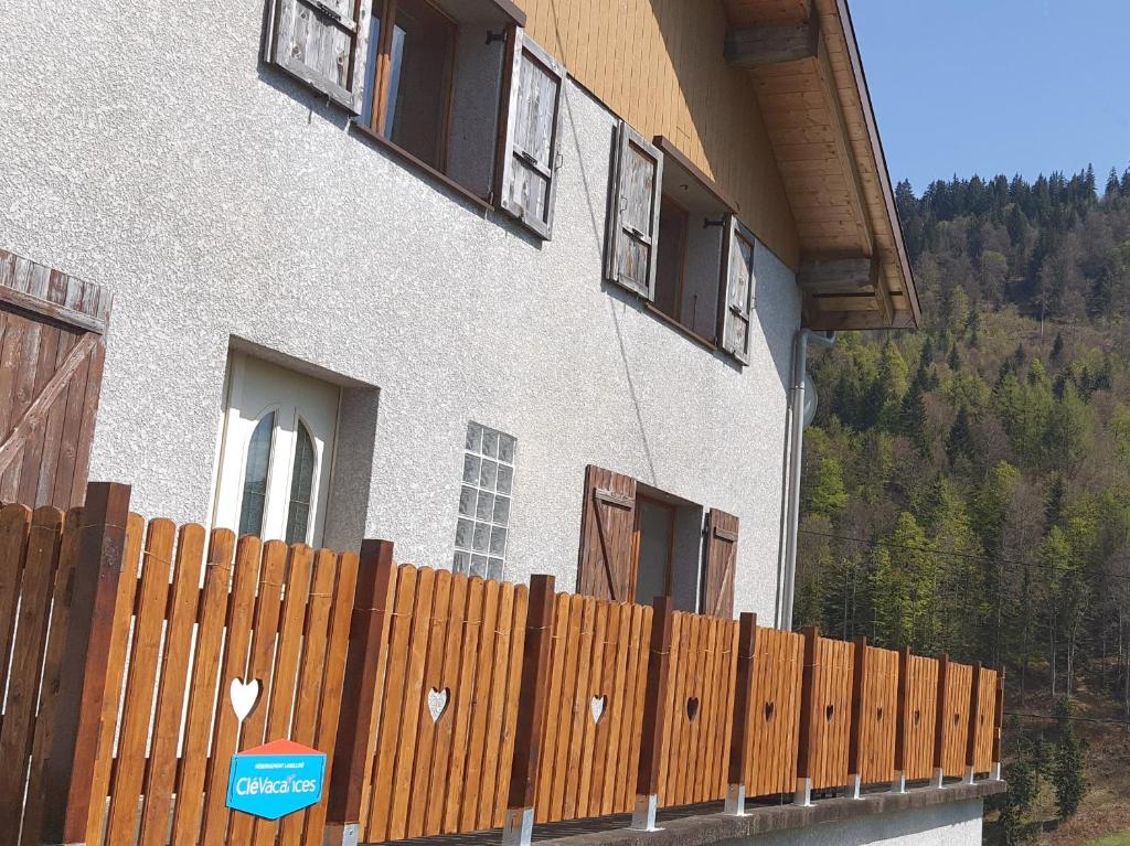 a fence in front of a building with windows at Le Chalet de Poche - Gite 2 étoiles - 5 pers in Habère-Poche