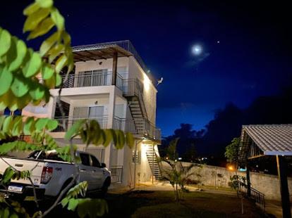 un camion blanc garé devant un bâtiment la nuit dans l'établissement Pousada Morada Caninde, à Alto Paraíso de Goiás